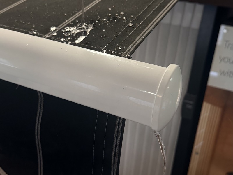 Built-in rain gutter on Aristocrat retractable awning channeling water through front bar