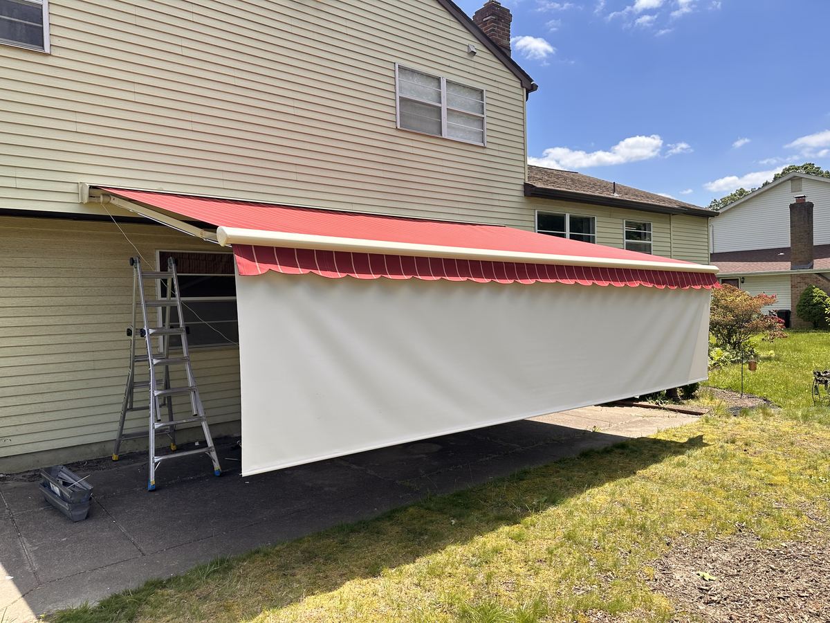Retractable awning with solar drop shade screen